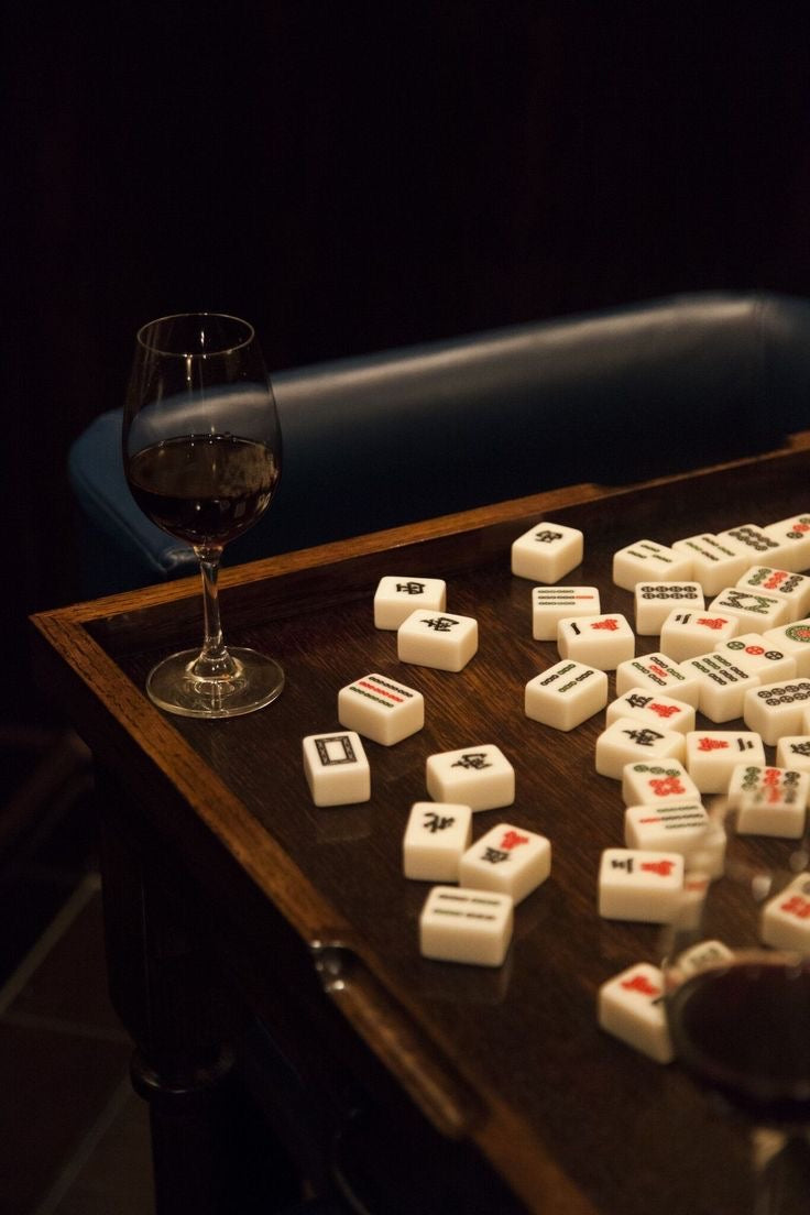 Mahjong tiles on a dark wooden table